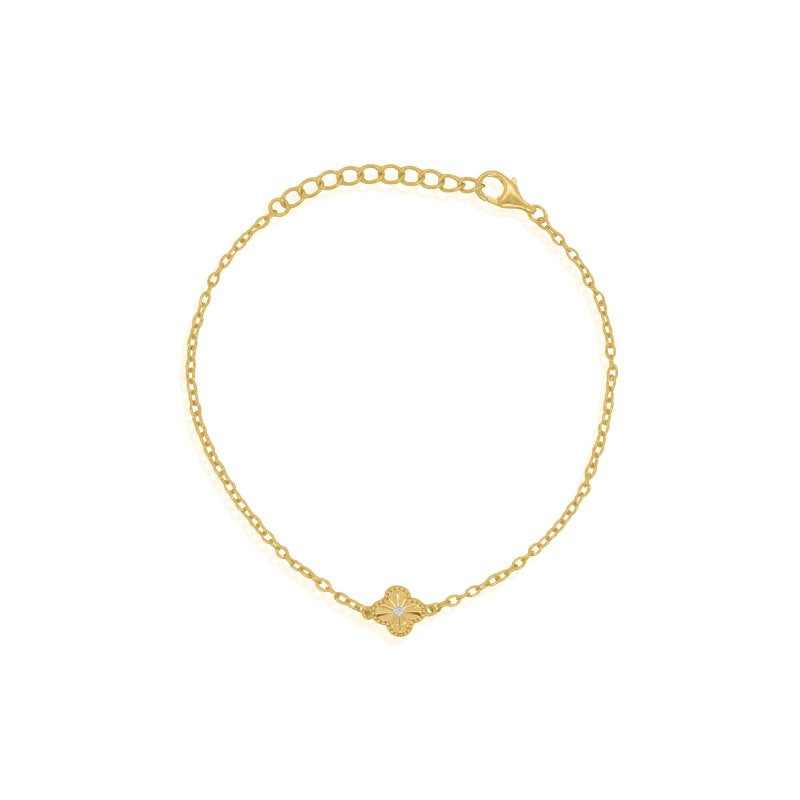 Gold bracelet with a small clover element on a white background
