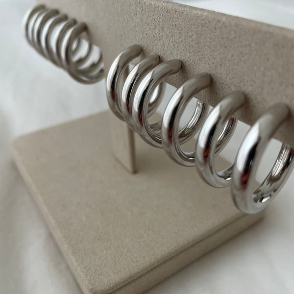Row of sterling silver hoop earrings on jewellery stand
