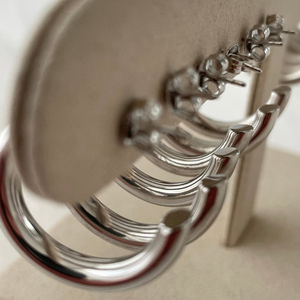Row of sterling silver hoop earrings on jewellery stand showing the side view