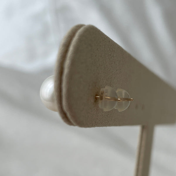 Close-up of a gold earring on a white background