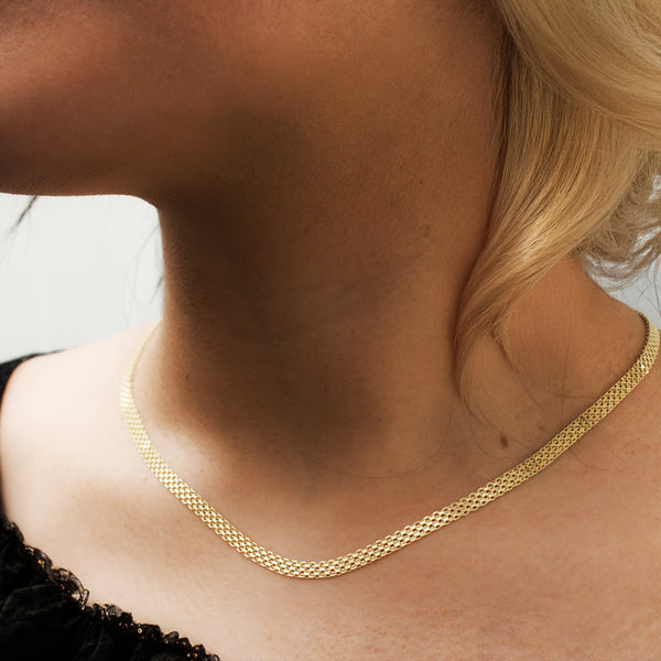 Gold necklace on a person with a blurred background