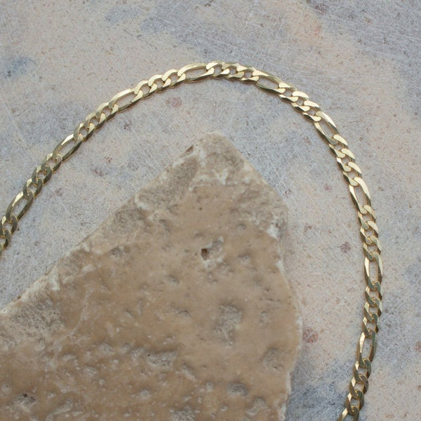 Gold chain on a stone surface