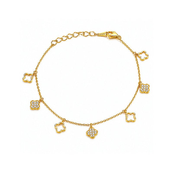 A gold chain bracelet with seven clover-shaped charms, five of which are adorned with small pavé-set clear stones, shown on a plain white background.
