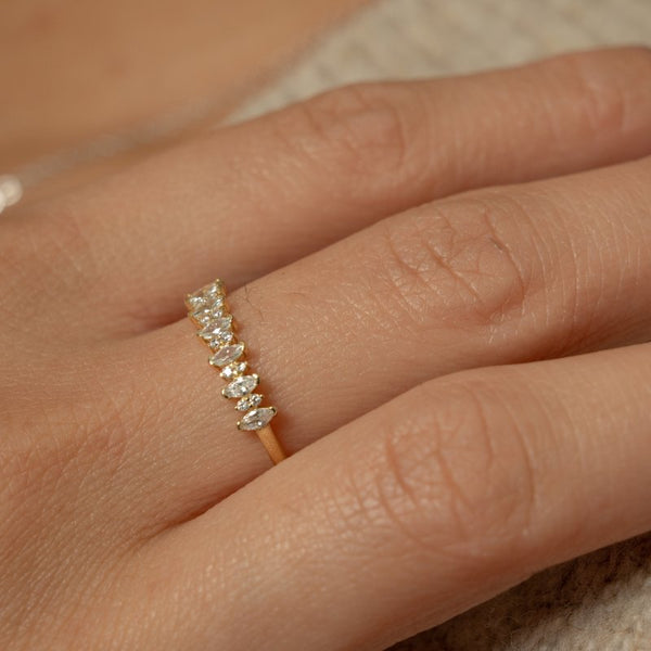Gold ring with small diamonds on a person's finger