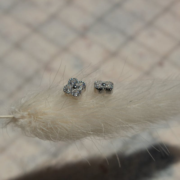 Silver earrings with gemstones on a textured surface